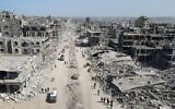 Sur cette vue aérienne, des personnes marchent au milieu des décombres dans Gaza-City, au nord de l'enclave côtière, le 11 octobre 2025 (Crédit : AFP).
