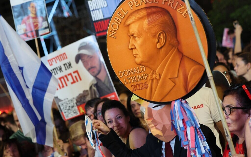 Un manifestant porte une réplique du prix Nobel de la paix représentant le président américain Donald Trump, lors d'un rassemblement sur la place des Otages à Tel Aviv, le 11 octobre 2025. (Crédit : Jack GUEZ / AFP)