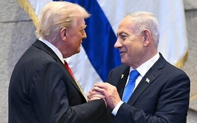 Le président américain Donald Trump (à gauche) tenant la main du Premier ministre Benjamin Netanyahu, à la Knesset, à Jérusalem, le 13 octobre 2025 (Crédit : Saul Loeb/POOL/AFP) Le président américain Donald Trump (à gauche) tenant la main du Premier ministre Benjamin Netanyahu, à la Knesset, à Jérusalem, le 13 octobre 2025 (Crédit : Saul Loeb/POOL/AFP)