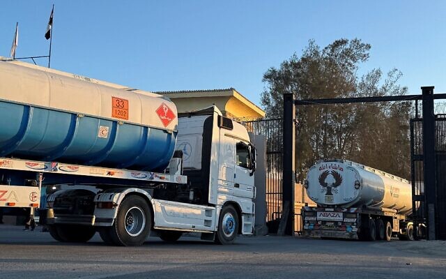 Des camions chargés de carburant traversent la frontière égyptienne au poste-frontière de Rafah, dans le sud de la bande de Gaza, tôt le matin du 15 octobre 2025. (Crédit : AFP)