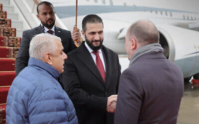 Cette photo diffusée par l'agence de presse officielle syrienne SANA montre le président intérimaire syrien Ahmed al-Sharaa (au centre) descendant d'un avion à son arrivée à Moscou, le 15 octobre 2025. (Crédit : AFP PHOTO / HANDOUT / SANA)