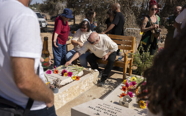 Les membres du kibboutz Kfar Aza se recueillent devant les tombes des victimes lors d'une cérémonie commémorative en hommage aux personnes tuées lors de l'attaque du Hamas contre Israël le 7 octobre 2023, au kibboutz Kfar Aza, situé dans le sud d'Israël près de la frontière avec Gaza, le 16 octobre 2025. (Crédit : Photo de Maya Levin / AFP) Les membres du kibboutz Kfar Aza se recueillent devant les tombes des victimes lors d'une cérémonie commémorative en hommage aux personnes tuées lors de l'attaque du Hamas contre Israël le 7 octobre 2023, au kibboutz Kfar Aza, situé dans le sud d'Israël près de la frontière avec Gaza, le 16 octobre 2025. (Crédit : Photo de Maya Levin / AFP)