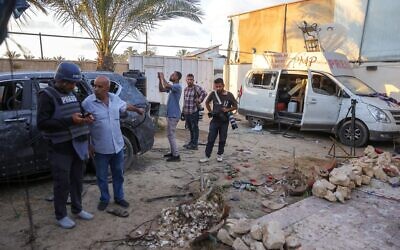 Des civils et des membres de la presse inspectant les dégâts causés par une frappe israélienne qui a visé une maison utilisée par des journalistes, dans la ville d'al-Zawayda, près de Deir al-Balah, dans le centre de la bande de Gaza, le 19 octobre 2025. (Crédit : Bashar Taleb/AFP)