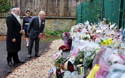 Le roi Charles III d'Angleterre regardant des bouquets de fleurs lors d'une visite à la synagogue Heaton Park Hebrew Congregation, à Crumpsall, au nord de Manchester, le 20 octobre 2025. Le 2 octobre 2025, un terroriste a foncé avec sa voiture dans la foule devant la synagogue avant de poignarder plusieurs personnes, faisant deux morts et trois blessés. (Crédit : Chris Jackson/POOL/AFP)