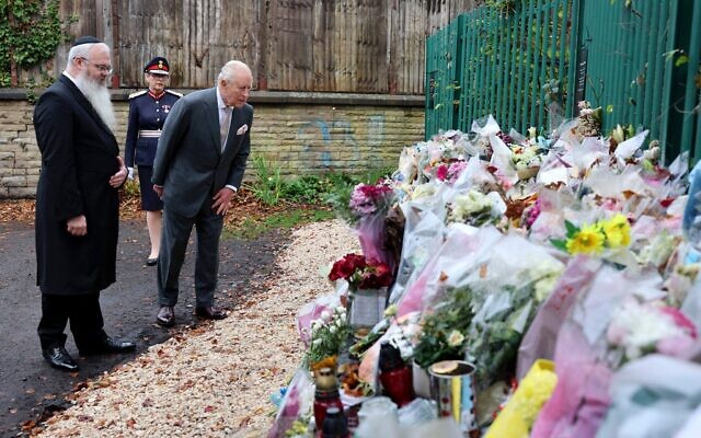 Le roi Charles III d'Angleterre regardant des bouquets de fleurs lors d'une visite à la synagogue Heaton Park Hebrew Congregation, à Crumpsall, au nord de Manchester, le 20 octobre 2025. Le 2 octobre 2025, un terroriste a foncé avec sa voiture dans la foule devant la synagogue avant de poignarder plusieurs personnes, faisant deux morts et trois blessés. (Crédit : Chris Jackson/POOL/AFP) Le roi Charles III d'Angleterre regardant des bouquets de fleurs lors d'une visite à la synagogue Heaton Park Hebrew Congregation, à Crumpsall, au nord de Manchester, le 20 octobre 2025. Le 2 octobre 2025, un terroriste a foncé avec sa voiture dans la foule devant la synagogue avant de poignarder plusieurs personnes, faisant deux morts et trois blessés. (Crédit : Chris Jackson/POOL/AFP)