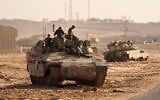 Les troupes de l’armée israélienne déployées le long de la frontière entre Israël et la bande de Gaza prenant position dans leurs véhicules blindés près de la barrière frontalière, le 21 octobre 2025. (Crédit : Jack Guez/AFP)