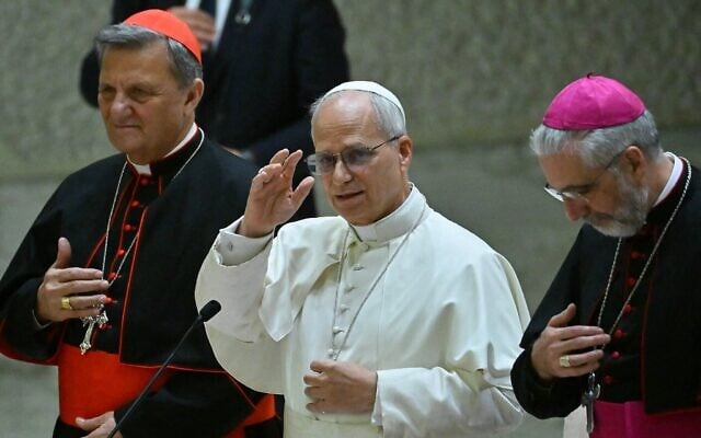 Le pape Léon XIV donne sa bénédiction, aux côtés du cardinal Mario Grech (à gauche) et de l'évêque Luis Marin de San Martin (à droite), après avoir participé au Synode des équipes et des organes participatifs dans la salle Paul VI au Vatican, le 24 octobre 2025. (Crédit : Filippo MONTEFORTE / AFP) Le pape Léon XIV donne sa bénédiction, aux côtés du cardinal Mario Grech (à gauche) et de l'évêque Luis Marin de San Martin (à droite), après avoir participé au Synode des équipes et des organes participatifs dans la salle Paul VI au Vatican, le 24 octobre 2025. (Crédit : Filippo MONTEFORTE / AFP)