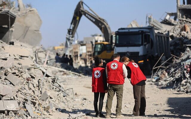 Des membres de la Croix-Rouge observent une opération visant à récupérer le corps d'un otage dans le quartier d'al-Tuffah, à Gaza, le 27 octobre 2025. (Crédit : Omar AL-QATTAA / AFP).