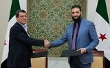 Le président par intérim de la Syrie, Ahmad al-Sharaa, à droite, serre la main de Mazloum Abdi, commandant des Forces démocratiques syriennes kurdes soutenues par les États-Unis, à Damas, en Syrie, le 10 mars 2025. (Crédit : SANA via AP)