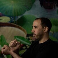 L'otage israélien libéré Tal Shoham, qui était détenu par des terroristes du Hamas dans la bande de Gaza, montre comment ses ravisseurs l'ont menotté, à Tel Aviv, le 22 avril 2025. (Crédit : AP Photo/Maya Alleruzzo)