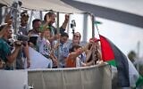 La militante suédoise pour le climat Greta Thunberg (centre gauche) saluant depuis un bateau participant à une flottille civile à destination de Gaza, qui vise à briser les restrictions maritimes strictes imposées par Israël sur Gaza, à Barcelone, en Espagne, le 31 août 2025. (Crédit : Emilio Morenatti/AP)