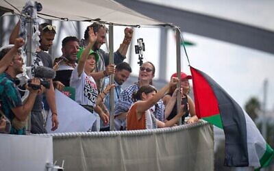 La militante suédoise pour le climat Greta Thunberg (centre gauche) saluant depuis un bateau participant à une flottille civile à destination de Gaza, qui vise à briser les restrictions maritimes strictes imposées par Israël sur Gaza, à Barcelone, en Espagne, le 31 août 2025. (Crédit : Emilio Morenatti/AP)