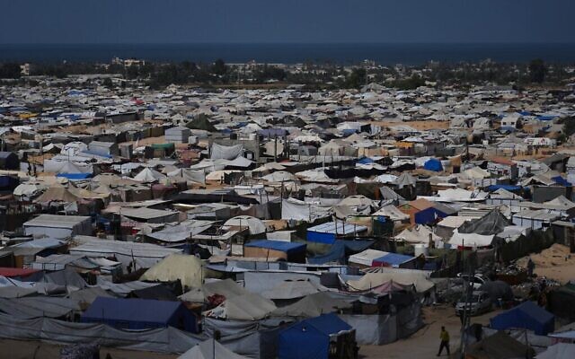 Photo d'illustration: Des Palestiniens déplacés traversent un camp de tentes à al-Muwasi, zone désignée comme sûre par Israël, à Khan Younès, dans le sud de la bande de Gaza, le 29 septembre 2025. (Crédit : AP Photo/Jehad Alshrafi)