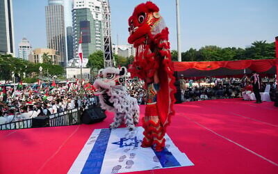 Des danseurs en costumes de lions piétinent  un drapeau israélien lors d'un rassemblement organisé en solidarité avec les Palestiniens de Gaza, à Jakarta, en Indonésie, le dimanche 12 octobre 2025. (Crédit : AP/Tatan Syuflana)