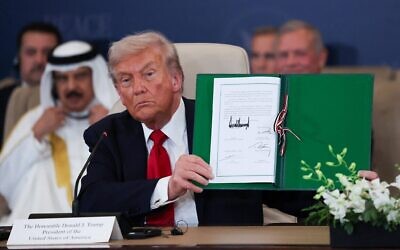 Le président américain Donald Trump posant avec un accord signé lors d'un sommet des dirigeants mondiaux sur la fin de la guerre à Gaza, à Charm el-Cheikh, en Égypte, le 13 octobre 2025. (Crédit : Suzanne Plunkett/AP)