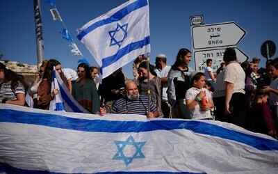 Des personnes se rassemblent pour accueillir l'otage israélien Avinatan Or, récemment libéré après avoir été retenu captif par le Hamas à Gaza, alors qu'il rentre de l'hôpital vers son domicile dans l'implantation de Shilo, en Cisjordanie, le 21 octobre 2025. (Crédit : AP/Ohad Zwigenberg)