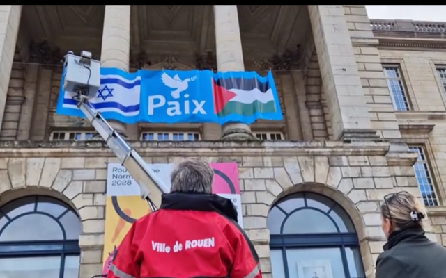 La banderole réunissant un drapeau palestinien et un drapeau israélien, accorchée sur la mairie de Rouen, le jour de sa pose. (Capture d'écran : YouTube)
