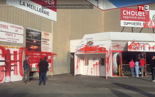 La façade de la salle de basket de Cholet vandalisée à la peinture rouge avant un match opposant l'équipe locale à l'Hapoël Unet Holon, le 18 octobre. (Capture d'écran : YouTube)