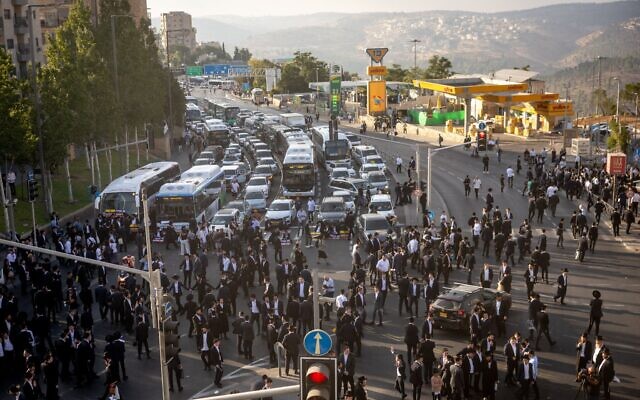 Des Juifs ultra-orthodoxes bloquant une route lors d'une manifestation contre l'emprisonnement des réfractaires à la conscription dans l'armée israélienne, à Jérusalem, le 18 septembre 2025. (Crédit : Chaïm Goldberg/Flash90)