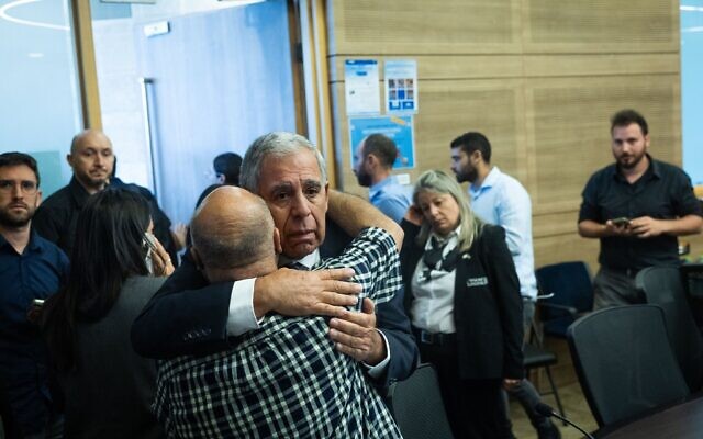 Le président de la commission de contrôle de l'État, le député Yesh Atid Mickey Levy, embrasse un membre d'une famille endeuillée lors d'une réunion de la commission à la Knesset, le 22 octobre 2025 (Crédit : Chaim Goldberg/Flash90)