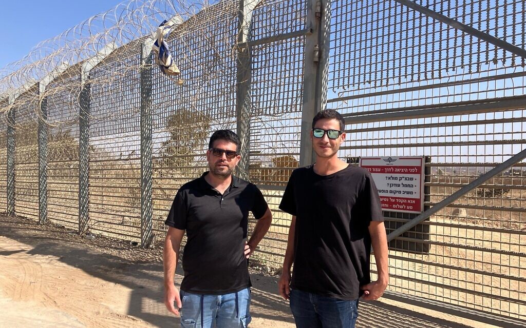 Les membres de l'équipe d'intervention d'urgence du kibboutz El Rom, Shimon Michael, à droite, et Gal Fitusi, se tiennent à la barrière frontalière, près du village syrien d'al-Hamidiya, le 23 octobre 2025. (Crédit: Diana Bletter/Times of Israel)