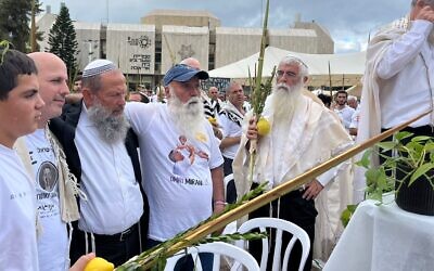 De gauche à droite : Shai Tzohar, cousin de l’otage assassiné Omer Neutra ; le rabbin Chaim Gantz ; Dani Miran, père de l’otage Omri Miran ; et le rabbin Dov Singer à la place des Otages, le 10 octobre 2025. (Crédit : Forum des familles des otages et des disparus)