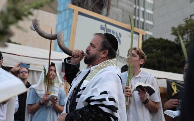 Des Juifs participant à un office matinal lors de HoShanna Rabba, dernier jour de la fête de Souccot, alors qu'ils attendent le retour des vingt otages vivants, sur la Place des Otages, à Tel Aviv, le 13 octobre 2025. (Crédit : Lizzy Shaanan/Mouvement de protestation israélien pour la démocratie)