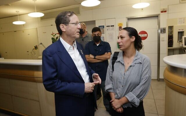 Le président Isaac Herzog s'entretenant avec Lishay Lavi, épouse de l'otage du Hamas Omri Miran, à l'hôpital Ichilov, le 12 octobre 2025. (Crédit : Avi Kanner)