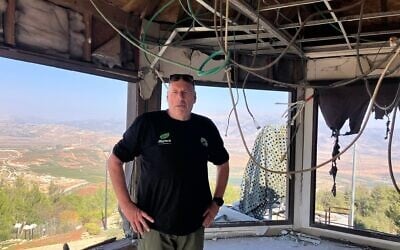 Ofer Moskovitz, porte-parole du kibboutz Misgav Am, se tenant dans le centre d'observation du kibboutz détruit par les roquettes du groupe terroriste chiite libanais du Hezbollah au cours des premières semaines de la guerre entre Israël et le Hezbollah, le 23 octobre 2025. (Crédit : Diana Bletter/Times of Israel)