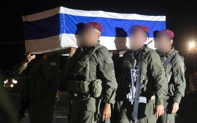 Des soldats de Tsahal saluent le cercueil contenant le corps de l'otage Lior Rudaeff après sa restitution par le Hamas, lors d'une brève cérémonie dans la bande de Gaza, tard le 7 novembre 2025. (Crédit : armée israélienne)