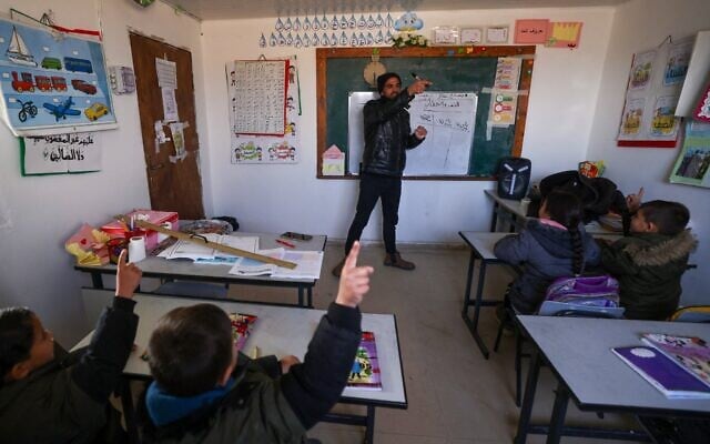 Des écoliers palestiniens fréquentent une école dans le village de Khalet al-Dabaa, à Masafer Yatta, dans le sud de la Cisjordanie, le 13 février 2025. (Crédit : Hazem Bader/AFP) Des écoliers palestiniens fréquentent une école dans le village de Khalet al-Dabaa, à Masafer Yatta, dans le sud de la Cisjordanie, le 13 février 2025. (Crédit : Hazem Bader/AFP)