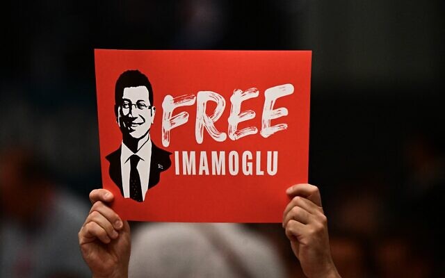 Un participant tient une pancarte sur laquelle on peut lire « Libérez Imamoglu », en référence à la détention du maire d'Istanbul, Ekrem Imamoglu, lors de la deuxième journée du congrès du Parti social-démocrate allemand (SPD) au City Cube de Berlin, le 28 juin 2025. (Crédit : Tobias SCHWARZ / AFP)