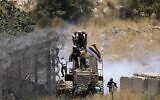 Les soldats israéliens utilisent des gaz lacrymogènes pour disperser la foule alors que des Druzes tentent de franchir la frontière syrienne sur le plateau du Golan, près de Majdal Shams, le 16 juillet 2025. (Crédit : Jalaa MAREY / AFP)
