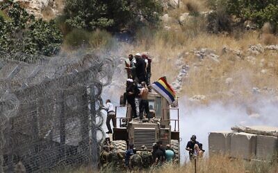 Les soldats israéliens utilisent des gaz lacrymogènes pour disperser la foule alors que des Druzes tentent de franchir la frontière syrienne sur le plateau du Golan, près de Majdal Shams, le 16 juillet 2025. (Crédit : Jalaa MAREY / AFP)
