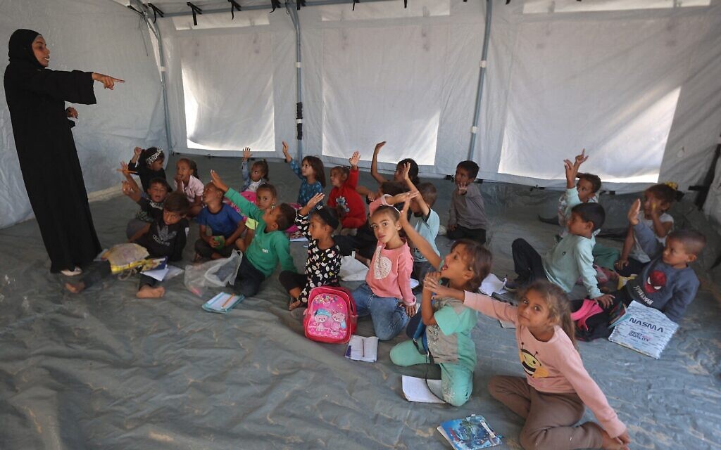 Des écoliers palestiniens assistent à un cours dans une école mise en place par l’association culturelle Mayasem avec le soutien de l’UNICEF, dans un camp de déplacés dans la région de Khan Younès, le 7 octobre 2025. (Crédit : Omar AL-QATTAA/AFP) Des écoliers palestiniens assistent à un cours dans une école mise en place par l’association culturelle Mayasem avec le soutien de l’UNICEF, dans un camp de déplacés dans la région de Khan Younès, le 7 octobre 2025. (Crédit : Omar AL-QATTAA/AFP)