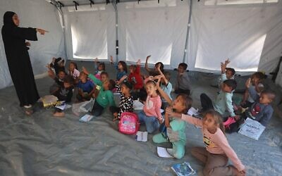 Des écoliers palestiniens assistent à un cours dans une école mise en place par l’association culturelle Mayasem avec le soutien de l’UNICEF, dans un camp de déplacés dans la région de Khan Younès, le 7 octobre 2025. (Crédit : Omar AL-QATTAA/AFP) Des écoliers palestiniens assistent à un cours dans une école mise en place par l’association culturelle Mayasem avec le soutien de l’UNICEF, dans un camp de déplacés dans la région de Khan Younès, le 7 octobre 2025. (Crédit : Omar AL-QATTAA/AFP)