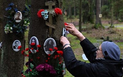 Des personnes visitent le mémorial où les victimes du régime du dictateur soviétique Joseph Staline ont été enterrées dans les bois à la périphérie de Saint-Pétersbourg, le 30 octobre 2025. La Russie célèbre la Journée des victimes des répressions politiques, au cours de laquelle les gens rendent hommage à la mémoire des milliers de victimes qui ont péri sous le régime communiste soviétique. (Crédit : Olga MALTSEVA / AFP)