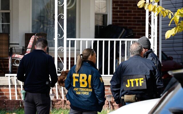 Des membres de la Force opérationnelle interagences contre le terrorisme du FBI se tiennent dans le jardin devant une maison à Dearborn, dans le Michigan, lors d'une perquisition, le 31 octobre 2025. (Crédit : JEFF KOWALSKY / AFP) Des membres de la Force opérationnelle interagences contre le terrorisme du FBI se tiennent dans le jardin devant une maison à Dearborn, dans le Michigan, lors d'une perquisition, le 31 octobre 2025. (Crédit : JEFF KOWALSKY / AFP)