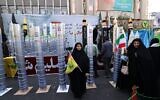 Des femmes se tiennent à côté de maquettes de missiles et d'une centrifugeuse d'enrichissement nucléaire lors d'un rassemblement devant l'ancienne ambassade américaine à Téhéran, le 4 novembre 2025 (Crédit : ATTA KENARE / AFP)
