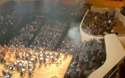 /Cette image extraite d'une vidéo UGC montre les incidents qui se sont produits dans la salle Pierre-Boulez de la Philharmonie de Paris, après qu'une personne ait allumé une bombe fumigène pendant un concert de l'Orchestre philharmonique d'Israël, le 6 novembre 2025 à Paris. (Crédit :  Jean-Michel TRANSON / AFPTV / AFP)