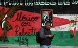 Un homme passe devant une fresque peinte sur une clôture métallique par des partisans pro-palestiniens dans le quartier dit "Palestine Plaza" à Mexico, le 7 novembre 2025. (Crédit : Yuri CORTEZ / AFP).