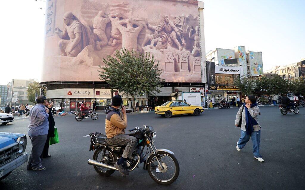 Des passants devant une grande banderole représentant des membres de la marine royale britannique capturés par le Corps des gardiens de la révolution islamique iranienne au cours des années précédentes, sur la place Enghelab à Téhéran, le 11 novembre 2025. (Crédit : ATTA KENARE / AFP) Des passants devant une grande banderole représentant des membres de la marine royale britannique capturés par le Corps des gardiens de la révolution islamique iranienne au cours des années précédentes, sur la place Enghelab à Téhéran, le 11 novembre 2025. (Crédit : ATTA KENARE / AFP)