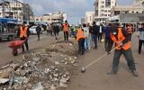 Des Gazaouis nettoyant les rues de Gaza-City, le 15 novembre 2025. (Crédit : Omar al-Qattaa/AFP)