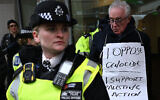 Un manifestant escorté par des policiers pour avoir participé à une manifestation de soutien au mouvement « Défendons nos jurys » et à sa campagne contre l’interdiction de Palestine Action, devant le ministère britannique de la Justice, à Londres, le 20 novembre 2025. (Crédit : Chris J Ratcliffe / AFP)