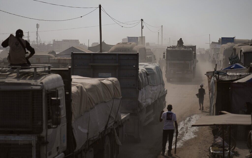 Des hommes armés escortant des camions transportant de l'aide humanitaire alors qu'ils traversent Khan Younès, dans le sud de la bande de Gaza, le 2 novembre 2025. (Crédit : Jehad Alshrafi/AP Photo)
