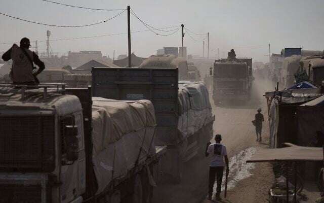Des hommes armés escortant des camions transportant de l'aide humanitaire alors qu'ils traversent Khan Younès, dans le sud de la bande de Gaza, le 2 novembre 2025. (Crédit : Jehad Alshrafi/AP Photo)