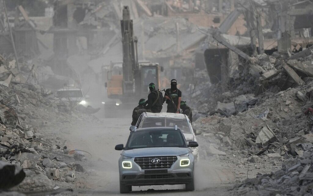 Des hommes armés du Hamas et des travailleurs égyptiens recherchent les corps des otages dans le quartier de Shijaiyah, à Gaza, le 5 novembre 2025. (Crédit : AP/Jehad Alshrafi) Des hommes armés du Hamas et des travailleurs égyptiens recherchent les corps des otages dans le quartier de Shijaiyah, à Gaza, le 5 novembre 2025. (Crédit : AP/Jehad Alshrafi)