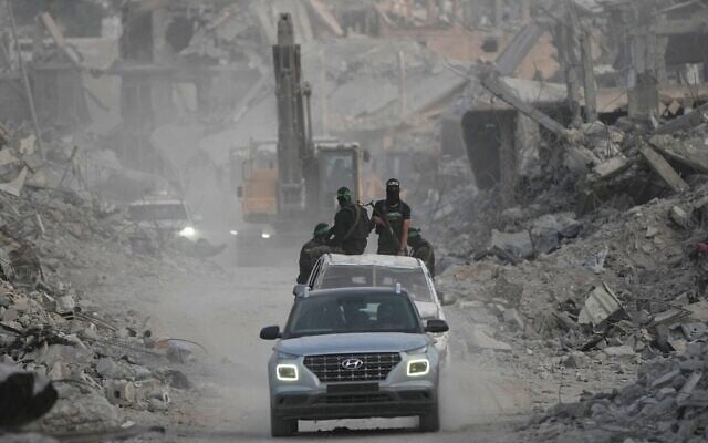 Des hommes armés du Hamas et des travailleurs égyptiens recherchent les corps des otages dans le quartier de Shijaiyah, à Gaza, le 5 novembre 2025. (Crédit : AP/Jehad Alshrafi) Des hommes armés du Hamas et des travailleurs égyptiens recherchent les corps des otages dans le quartier de Shijaiyah, à Gaza, le 5 novembre 2025. (Crédit : AP/Jehad Alshrafi)