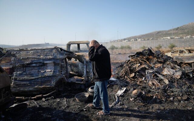 Mohammad Dalal examine des voitures calcinées dans sa casse automobile, incendiée la nuit précédente par des personnes que les habitants de la ville de Huwara, près de Naplouse en Cisjordanie, ont identifiées comme étant des résidents d'implantation israéliens, vendredi 21 novembre 2025. (Crédit : AP Photo/Nasser Nasser)