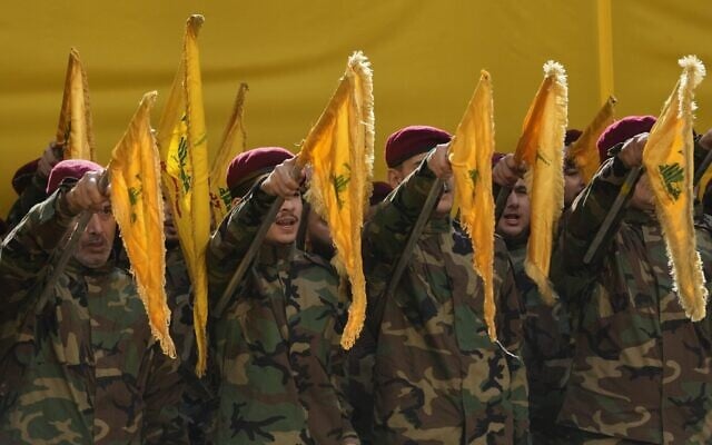 Des terroristes du Hezbollah brandissant les drapeaux du groupe terroriste chiite libanais et scandant des slogans alors qu'ils assistent aux funérailles du chef d'état-major du Hezbollah, Haytham Tabatabai, et de deux autres terroristes du Hezbollah éliminés lors d'une frappe aérienne israélienne, dans la banlieue sud de Beyrouth, au Liban, le 24 novembre 2025. (Crédit : Hussein Malla/AP Photo)